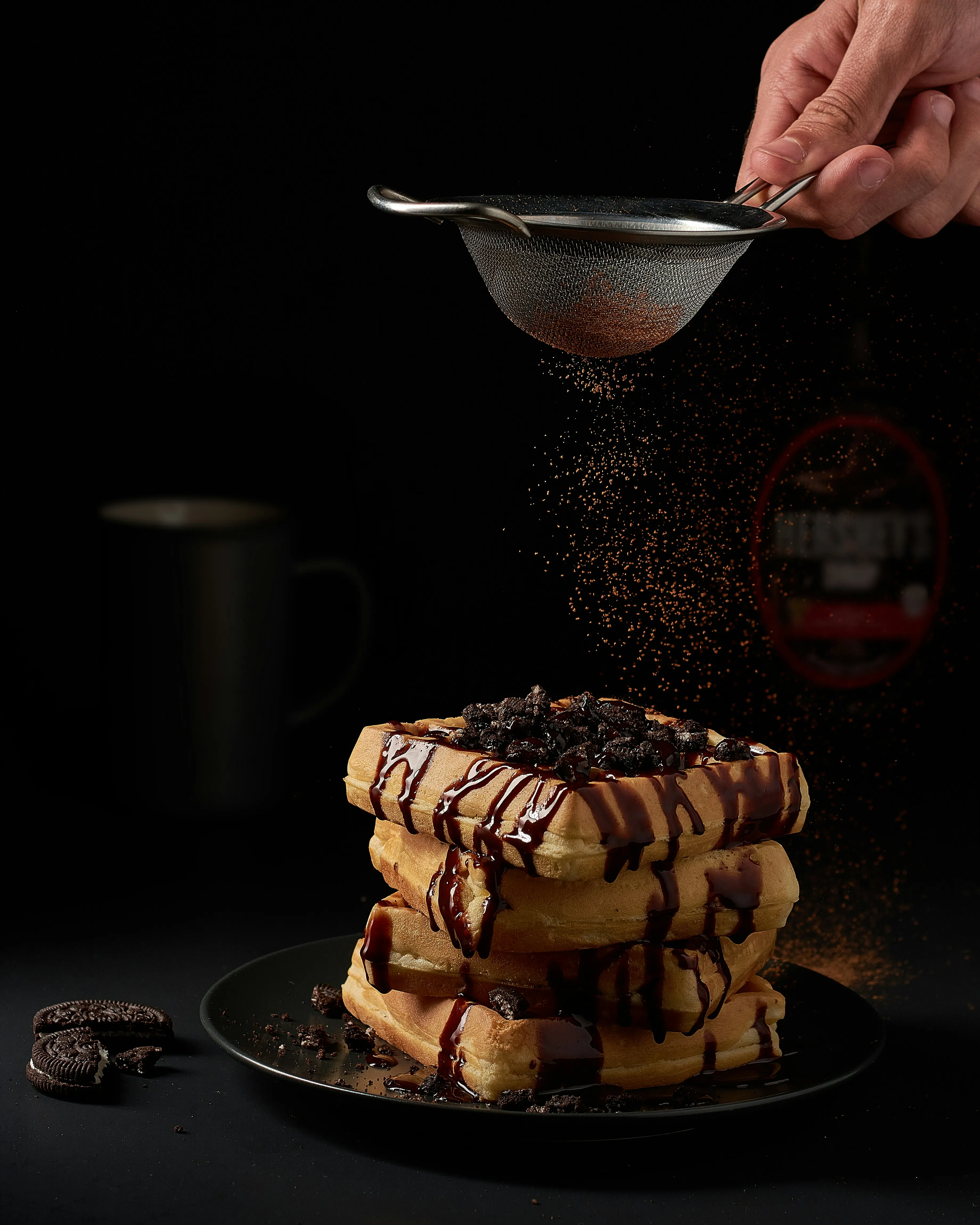 waffle stack getting sprinkled with chocolate powder